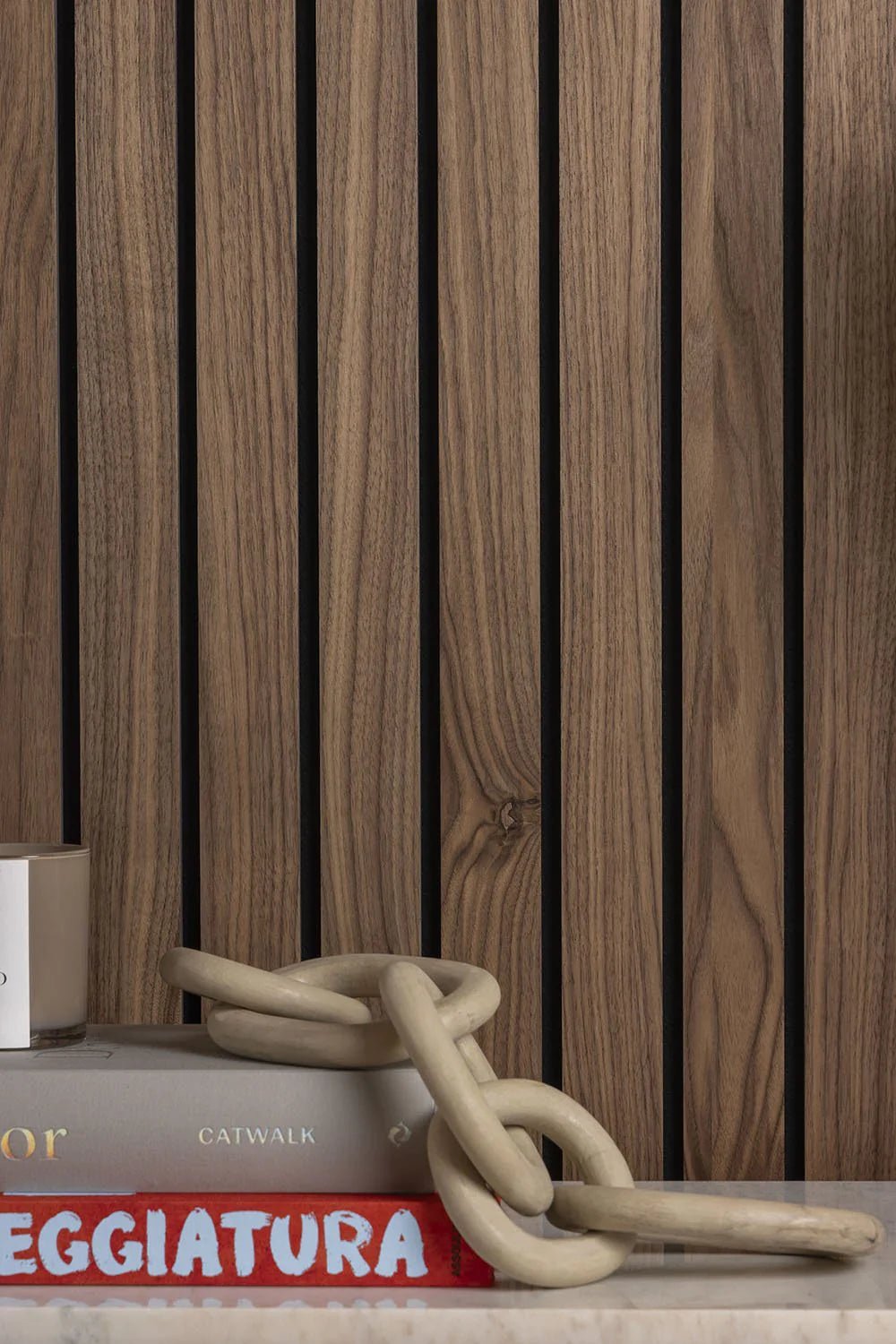 Detalle de listones de madera Walnut, libros y objetos de diseño